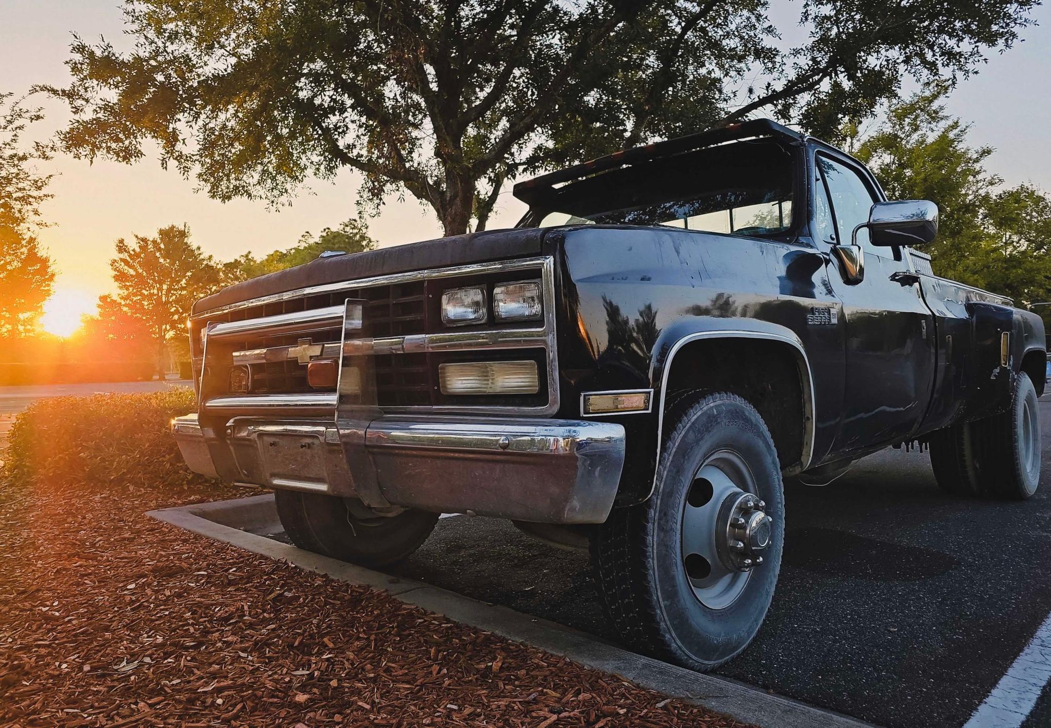 a vintage truck parked during a serene sunset evokes a sense of nostalgia and calm